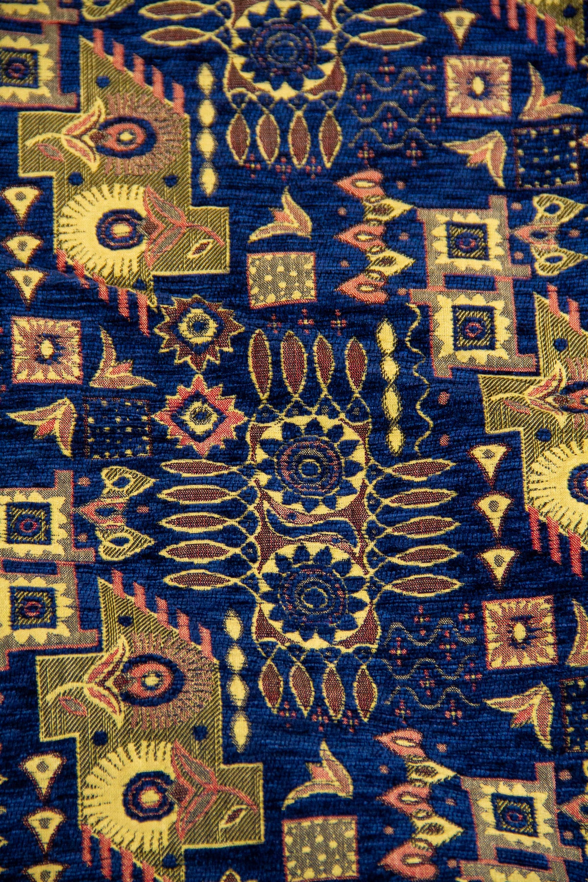 Detalle del diseño geométrico repetitivo sobre textil azul con tonos dorados.
