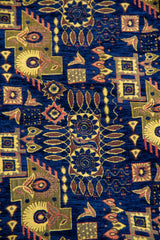Detalle del diseño geométrico repetitivo sobre textil azul con tonos dorados.