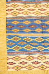 Detalle del diseño de rayas geométricas del textil beige con tonos azules 