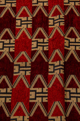 Detalle del diseño geométrico del textil bordó con figuras en V, triángulos y tonos bordó