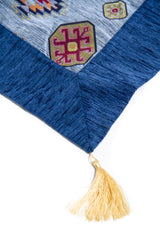 Detalle de textura del textil Kayseri celeste con guarda azul y fleco decorativo