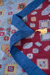 Detalle del reverso del textil decorativo celeste con guarda azul y fleco