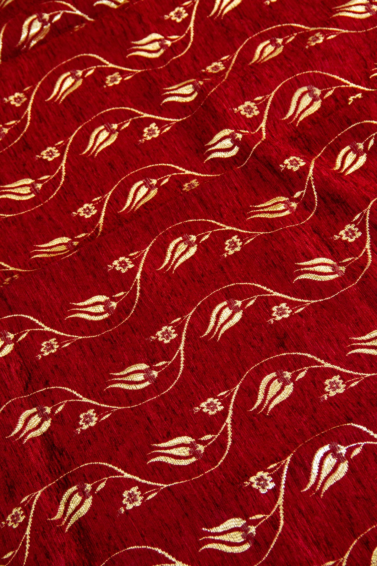 Detalle del diseño floral dorado sobre textil rojo Kayseri con textura suave y brillo decorativo