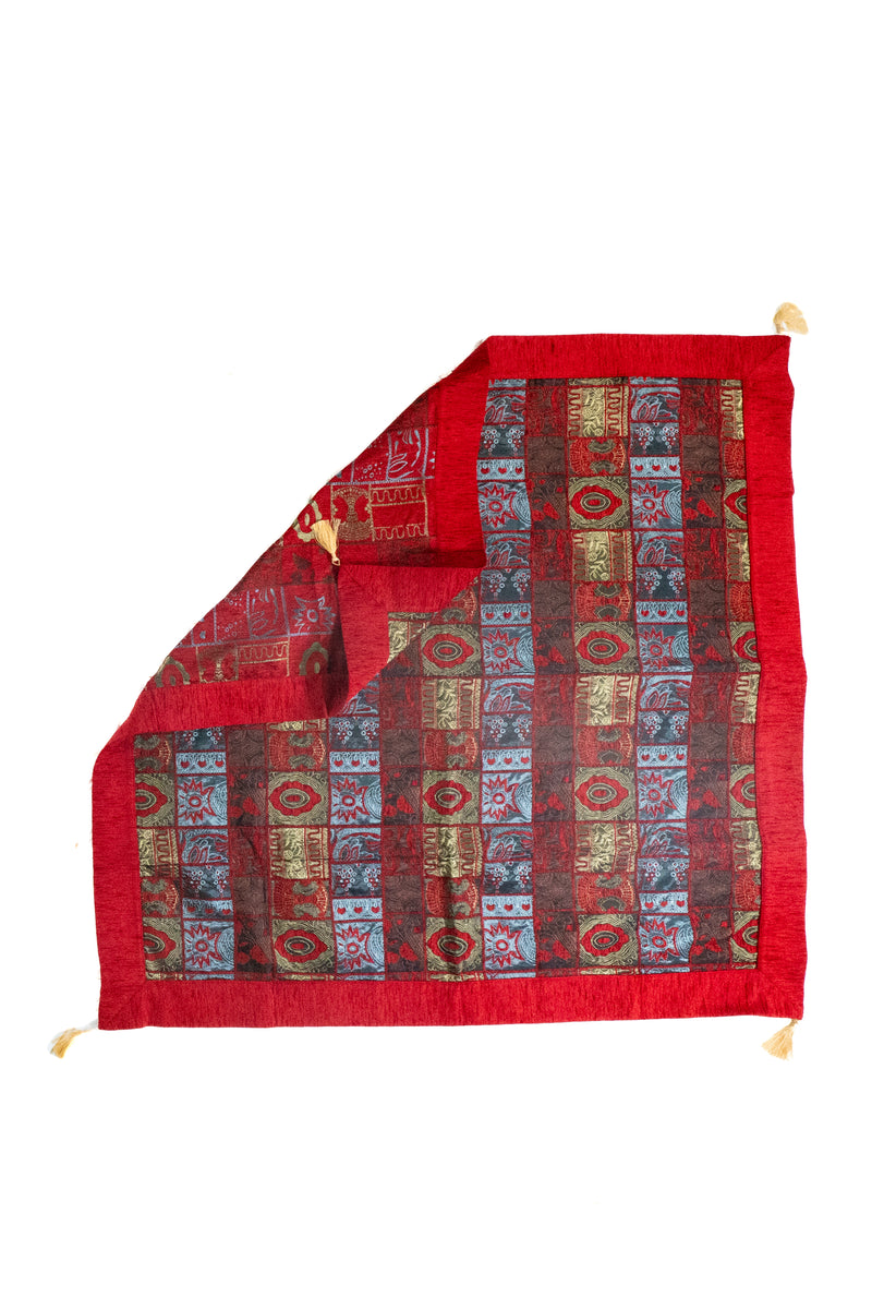 Textil decorativo rojo con diseño patchwork y reverso visible en formato cuadrado