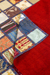 Detalle del reverso rojo y frente patchwork multicolor en textil decorativo rectangular