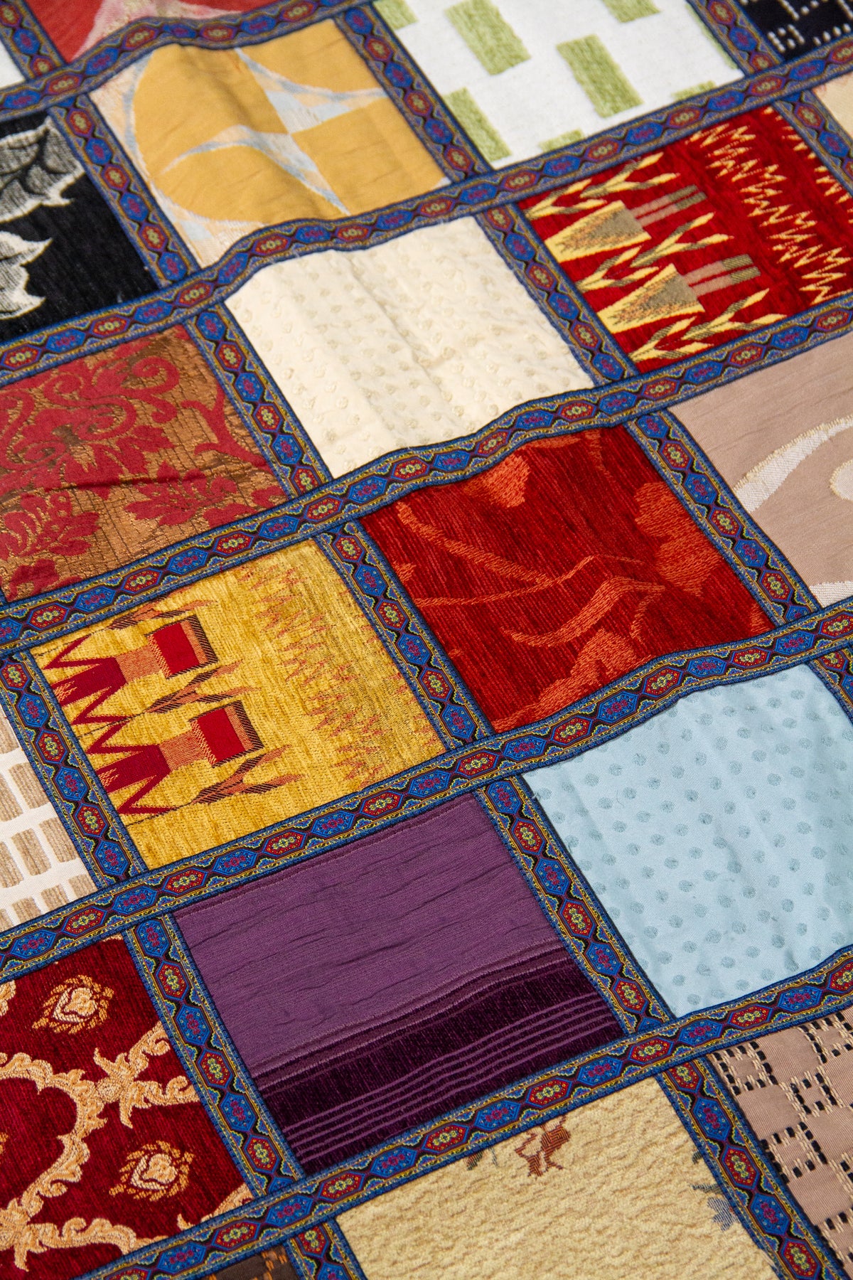 Detalle del diseño patchwork con cuadros florales y geométricos en textil multicolor