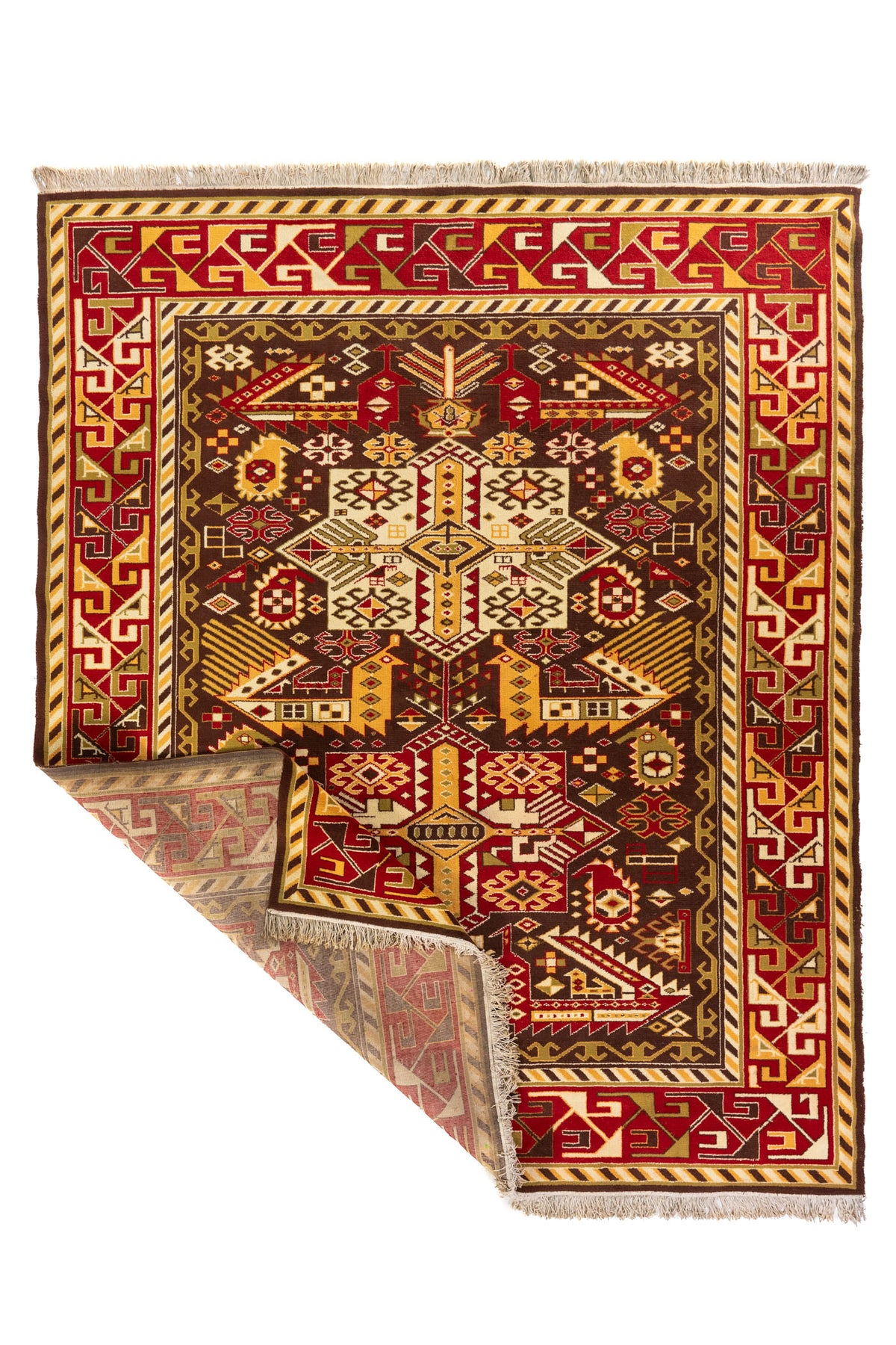 Alfombra geométrica en rojo y marrón con una esquina levantada mostrando el reverso y los flecos, fotografía sobre fondo blanco.