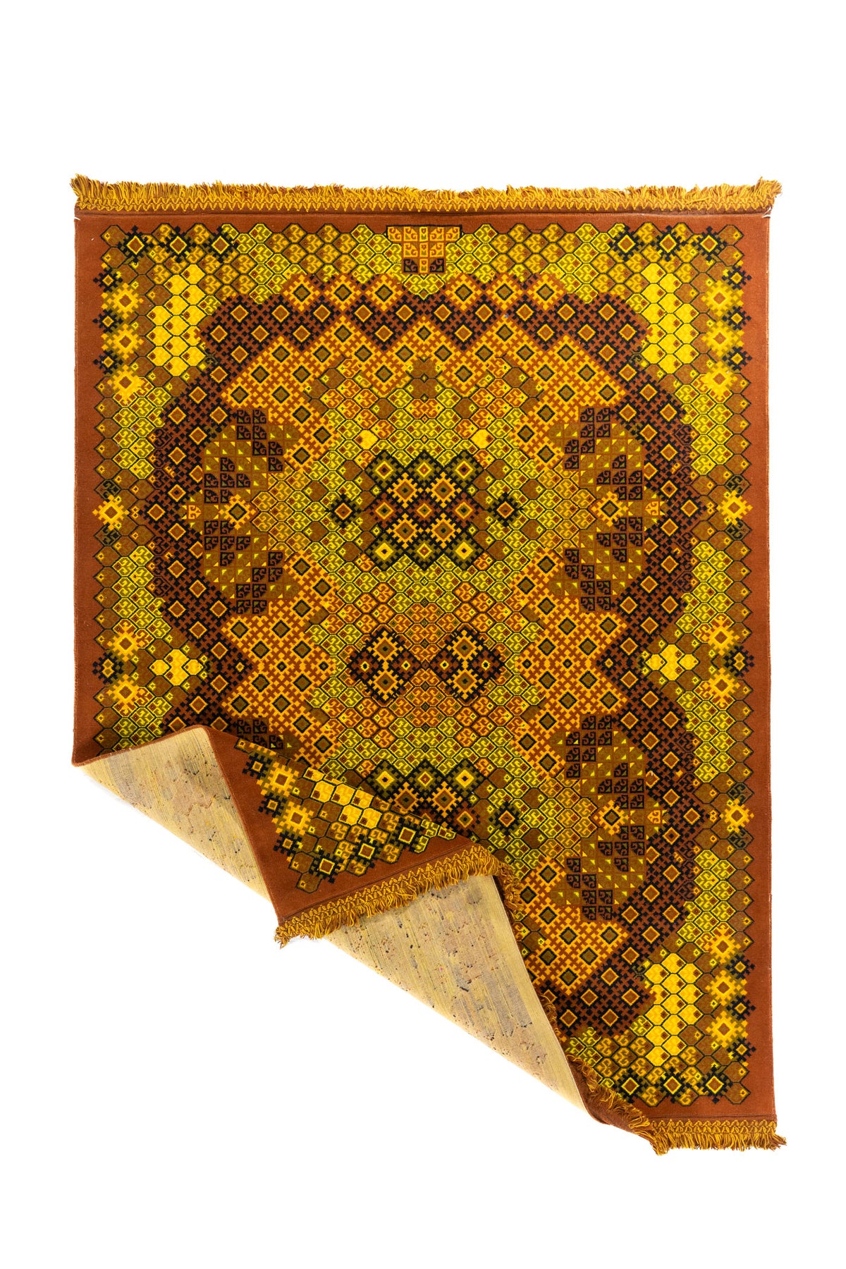 Alfombra geométrica en colores cálidos con una esquina doblada que muestra el reverso y los flecos