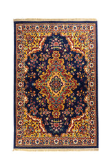 Alfombra clásica oriental en tonos azul, dorado y rojo con medallón central ornamental y guarda geométrica detallada.
