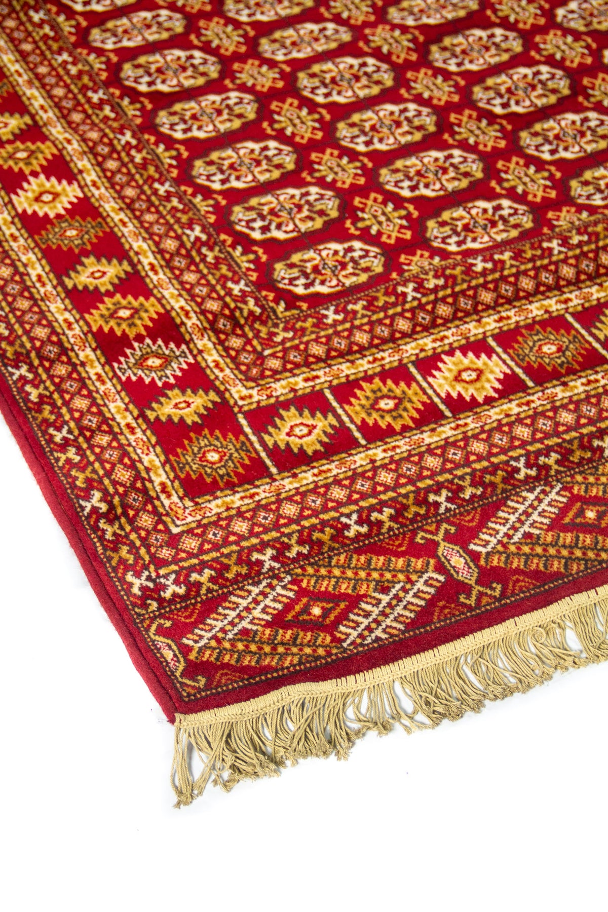 Primer plano de borde de alfombra oriental en tonos rojo y dorado con guardas geométricas y diseño tradicional de inspiración étnica.