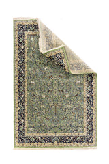 Alfombra oriental verde con esquina levantada que muestra el reverso, la flexibilidad y el tejido artesanal