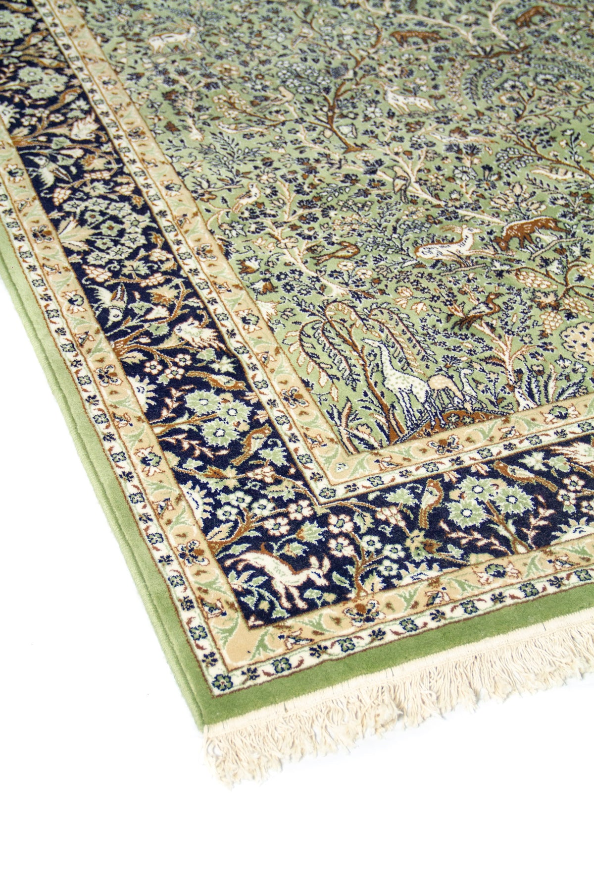 Detalle lateral de alfombra clásica verde con diseño floral y figuras animales sobre guarda azul oscuro