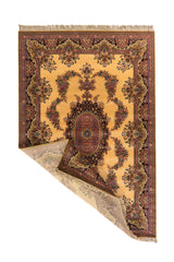 Alfombra beige y rosa con una esquina levantada, mostrando el reverso, los flecos y la flexibilidad del tejido.