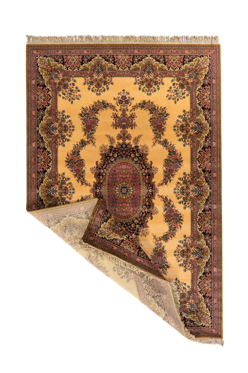 Alfombra beige y rosa con una esquina levantada, mostrando el reverso, los flecos y la flexibilidad del tejido.