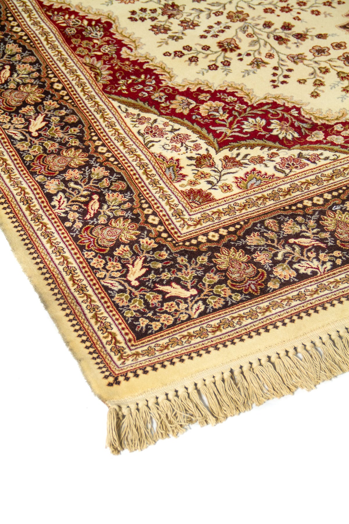 Primer plano de alfombra ornamental con centro beige, formas curvas en rojo y guarda floral oscura de gran detalle.