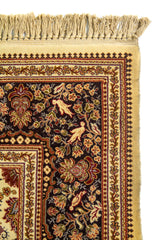 Detalle de borde superior de alfombra oriental con flecos, marco beige y guarda floral en tonos marrón oscuro, rojo y dorado.