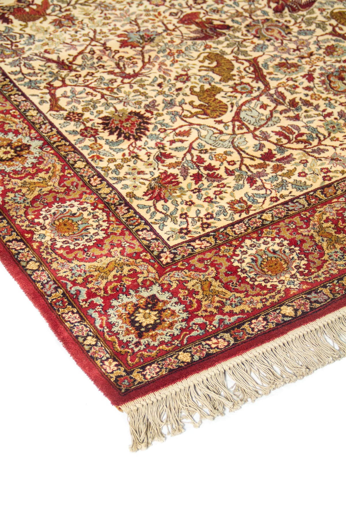 Primer plano de borde de alfombra oriental con guarda roja, ornamentos florales y delicados detalles en celeste, beige y dorado.