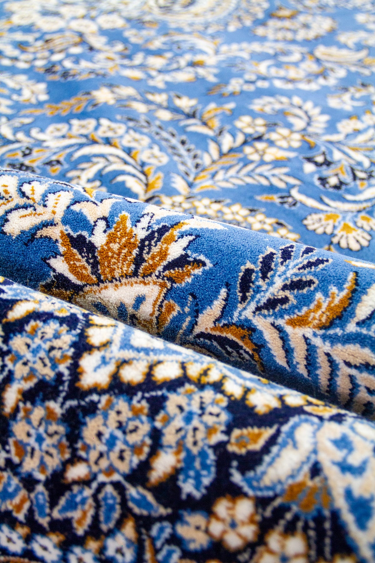 Toma cenital de la alfombra azul desplegada por completo, revelando la simetría de su diseño central.