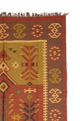 ombra Kilim Verde Rojo de Kerestegian con diseño geométrico tribal en tonos verdes, rojos y marrones, con motivos de rombos y líneas entrelazadas.