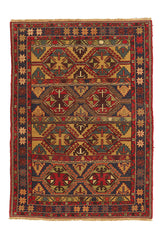 Alfombra kilim con diseño de rombos y figuras geométricas en tonos rojos, dorados y azul marino, con borde de flecos y patrones intrincados.