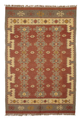 Alfombra artesanal de lana con diseño geométrico tribal en tonos rojizos y grises.