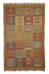 Alfombra artesanal de lana con diseño geométrico tribal en tonos tierra y óxido.