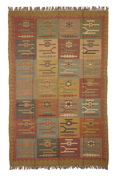 Alfombra artesanal de lana con diseño geométrico tribal en tonos tierra y óxido.