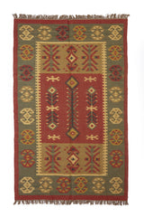 Alfombra artesanal de lana con diseño geométrico tribal en tonos cálidos y terrosos.