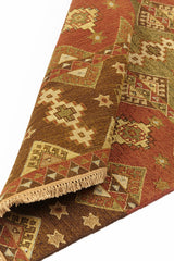 Alfombra kilim con diseño de mosaicos geométricos en tonos marrones, rojizos y beige, con detalles de flecos en el borde.
