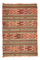 Alfombra kilim con diseño de rayas y patrones geométricos en tonos rojos, verdes y beige, mostrando detalles intrincados y flecos.