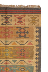 Alfombra artesanal de yute con diseño geométrico tribal en tonos tierra y óxido.