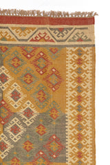 Alfombra rectangular de lana con patrón étnico y flecos. Tonos cálidos y textura natural, ideal para espacios acogedores.