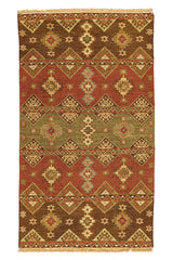 Alfombra kilim con diseño de mosaicos geométricos en tonos marrones, rojizos y beige, con detalles de flecos en el borde.