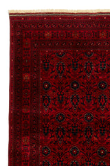 Alfombra persa y oriental con un diseño floral y geométrico en tonos rojos y beige, desplegada en un espacio con decoración moderna