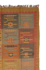 Alfombra artesanal de lana con diseño geométrico tribal en tonos tierra y óxido.
