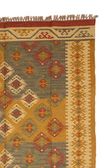 Alfombra artesanal de lana con patrón étnico en tonos neutros.
