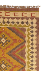 Alfombra rectangular de yute con patrón étnico inspirado en la naturaleza, con una paleta de colores terrosos y detalles en zigzag.