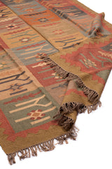  Alfombra artesanal de lana con diseño geométrico tribal en tonos tierra y óxido.
