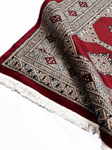 Elegante alfombra persa y oriental con patrones intrincados y colores vibrantes, expuesta en el suelo.