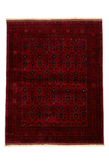 Alfombra persa y oriental con un diseño floral y geométrico en tonos rojos y beige, desplegada en un espacio con decoración moderna