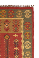 Alfombra artesanal de lana con diseño geométrico tribal en tonos cálidos y terrosos.
