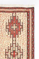 Alfombra oriental de lana con diseño geométrico y motivos florales. Colores cálidos y textura densa.